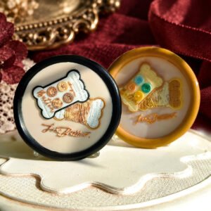 Vintage Button Shop wax seal impression showing decorative button cards and a spool of thread