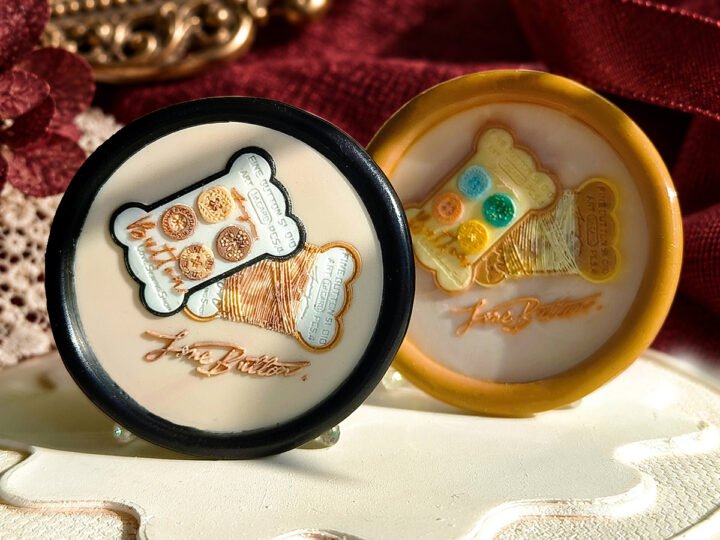 Vintage Button Shop wax seal impression showing decorative button cards and a spool of thread