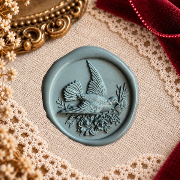 Dove and Floral Letter wax seal impression showing a flying bird carrying a letter among flowers and foliage