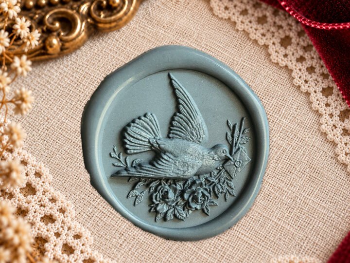 Dove and Floral Letter wax seal impression showing a flying bird carrying a letter among flowers and foliage