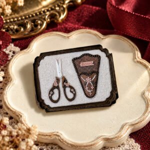 Colored wax impression showing floral scissors and sheath inside a shaped rectangular frame